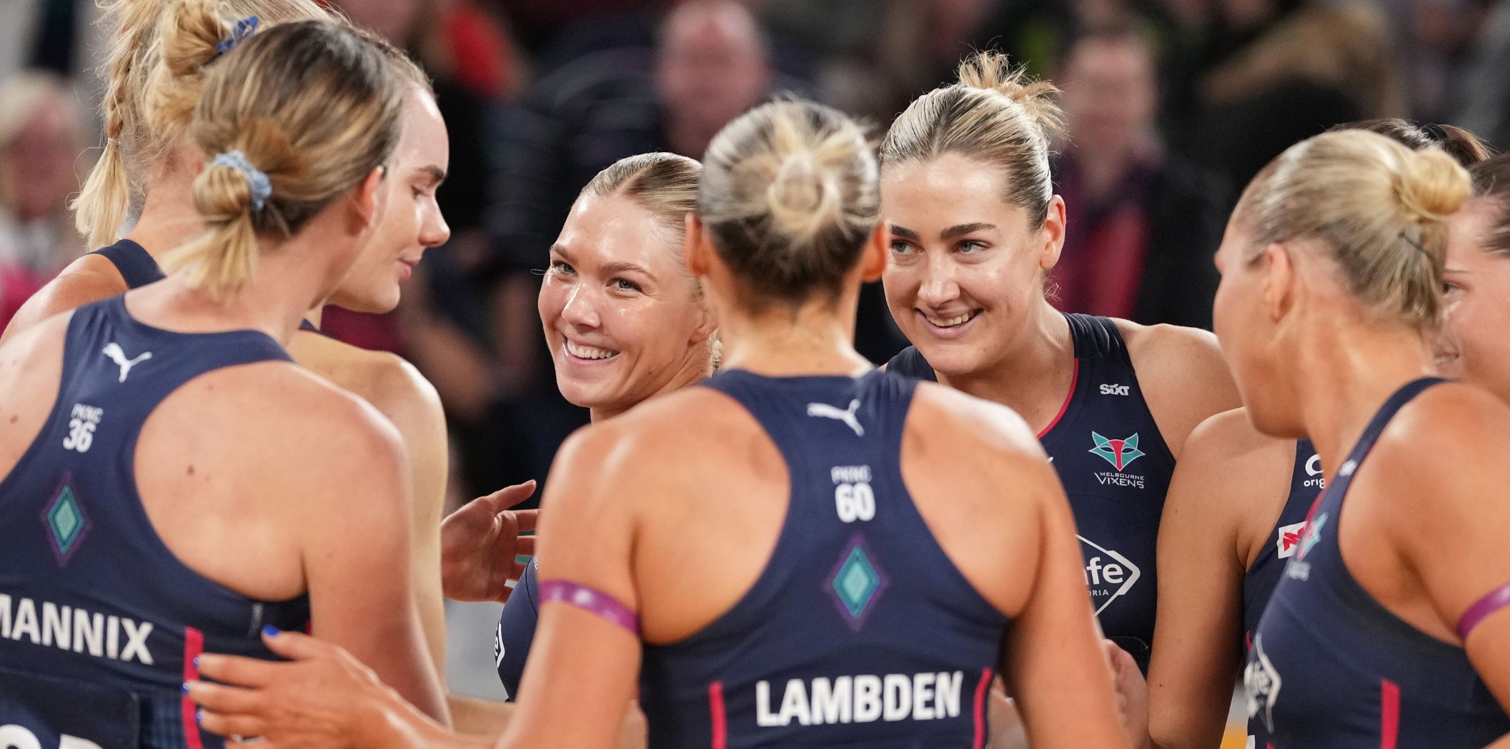 Melbourne Vixens players smile in their huddle post win