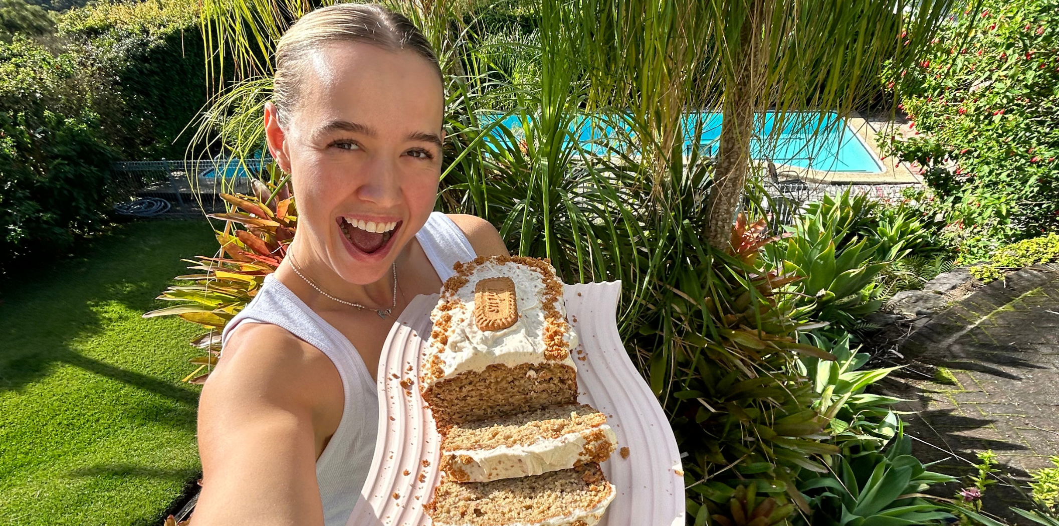 Teigan O'Shannassy poses with a Biscoff Banana Bread in front of a green garden