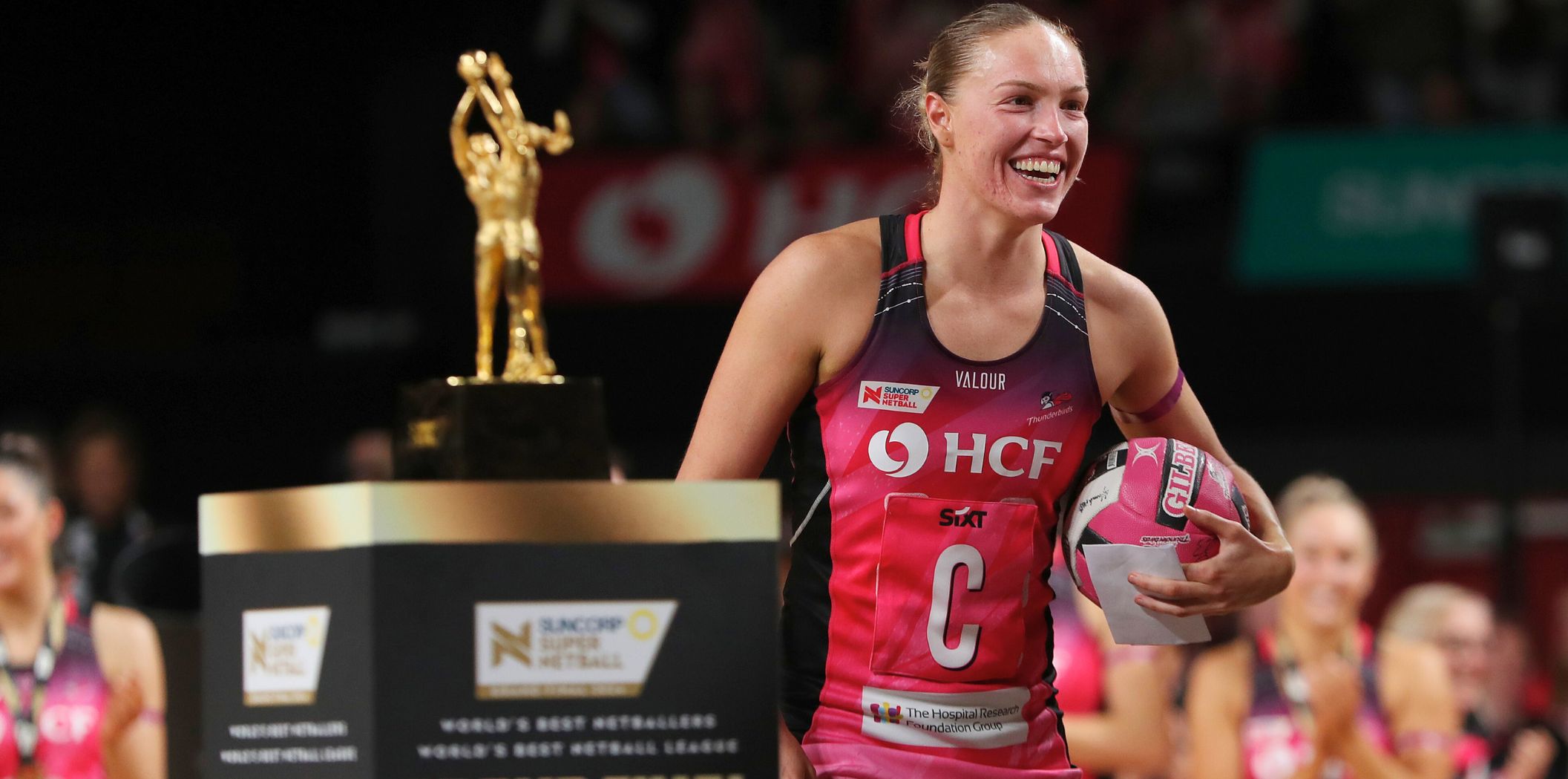 Hannah Petty smiles as she walks past the SSN trophy